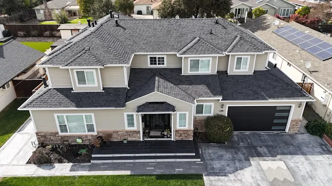 Large two-story home with new charcoal architectural shingle roof completed by Peak Edge Roofing